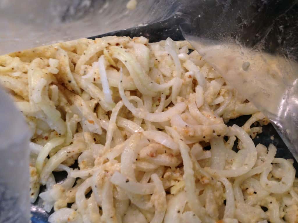 Mixing the sliced onions with flour and seasoning
